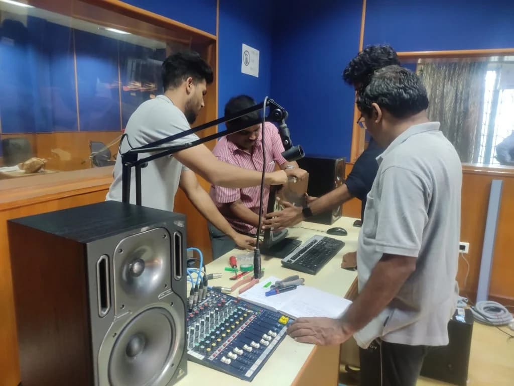 AirMedia team setting up microphones and consoles in a community radio studio