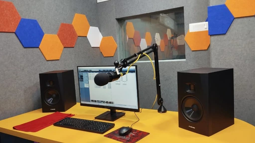 AirMedia studio control desk with ADAM Audio monitors, DAW, and microphone